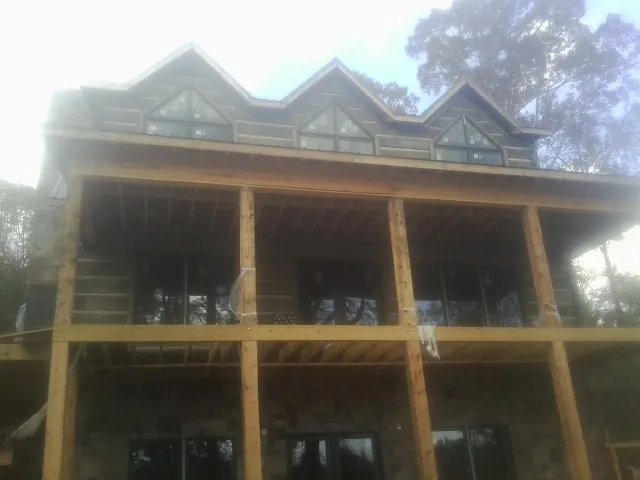 Dormers and porch framing on a large log home under construction — Roof Coating work by our crew in Pasadena